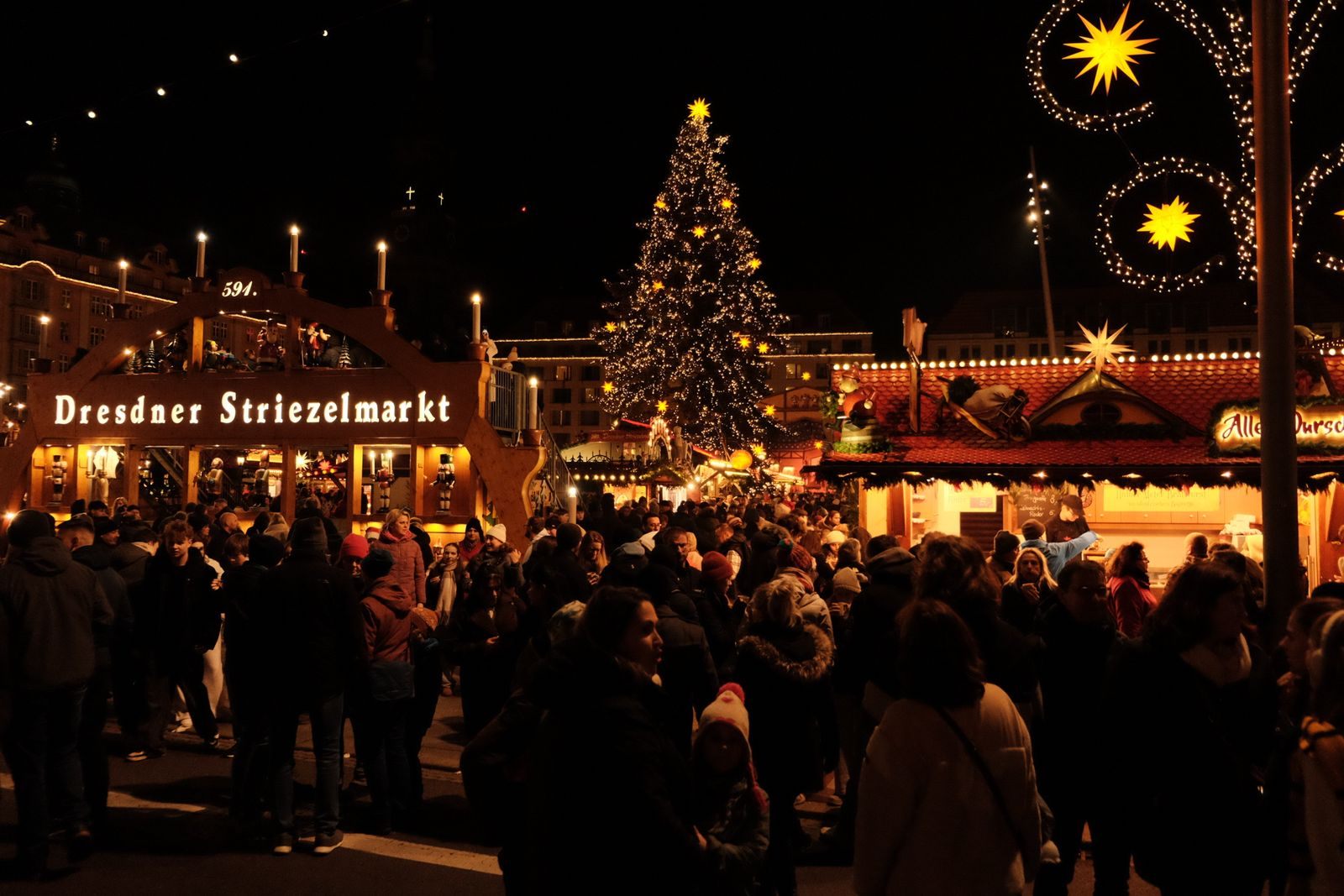 Evening crowds and a tall Christmas tree at Dresden&rsquo;s Striezelmarkt